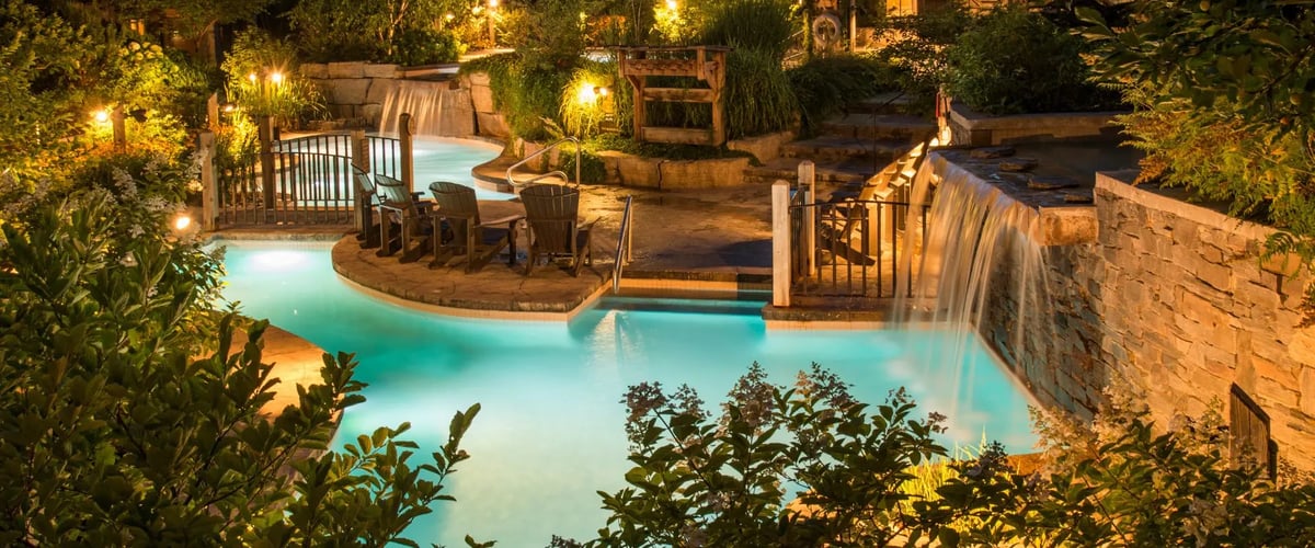 Les piscines et chutes du Scandinave Spa illuminées à la tombée de la nuit, créant une atmosphère féerique et intime.