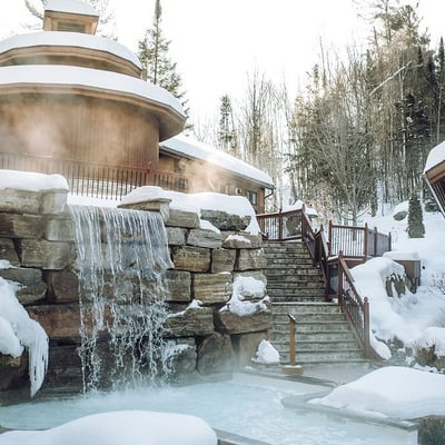 La chute nordique et les bains chauds de l'Amerispa Spa Nordique Morin-Heights sous la neige en hiver.