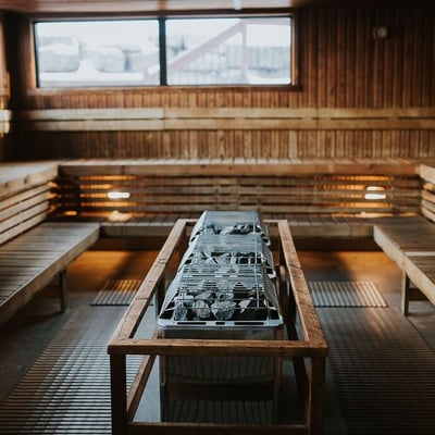 Intérieur du grand sauna finlandais de l'Amerispa Spa Nordique Morin-Heights, avec le poêle et les pierres chaudes au centre.