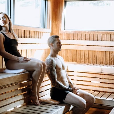 Un homme et une femme se relaxant dans le sauna finlandais en bois de l'Amerispa Morin-Heights.