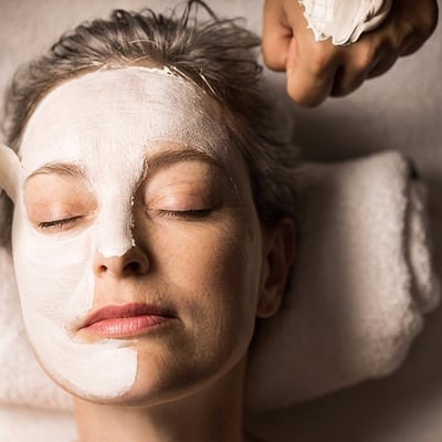 Femme recevant un soin du visage (facial) relaxant avec un masque blanc à l'Amerispa de Morin-Heights.
