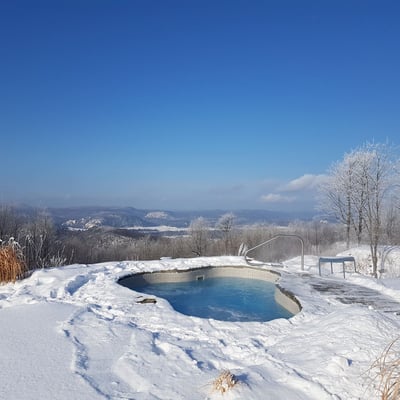 Bain nordique chauffé entouré de neige à l’Eco Spa Highland Laurentides.