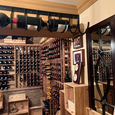 Cave à vin du Spa Auberge du Lac Morency avec bouteilles et présentoirs en bois.