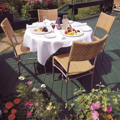 Table dressée pour un repas sur la terrasse de l'Excelsior Hôtel Spa, entourée de jardins fleuris.