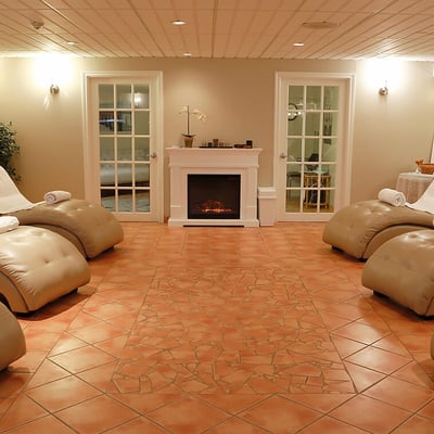 La salle de détente du spa de l'Hôtel Excelsior, avec ses chaises longues ergonomiques et son ambiance paisible.