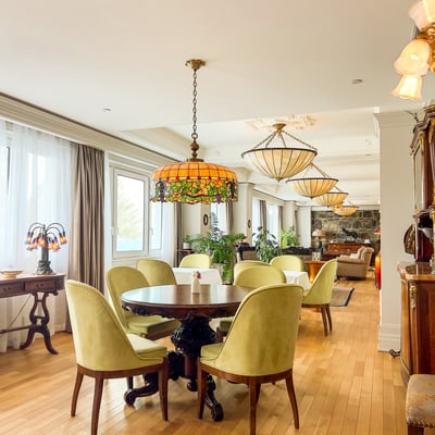 Salon du Spa StoneHaven Le Manoir avec chaises vertes, plancher de bois et lampes Tiffany.