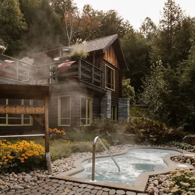 Un bain à remous au Scandinave Spa, avec un panneau en bois au premier plan indiquant 'SILENCE', un principe fondamental du lieu.