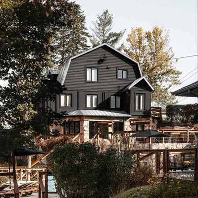 Vue d'un des bâtiments principaux du Strøm Spa à Saint-Sauveur, montrant son architecture moderne de style grange avec une base en pierre.