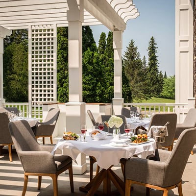 Terrasse élégante du restaurant du Spa StoneHaven Le Manoir avec tables dressées et vue sur la nature.